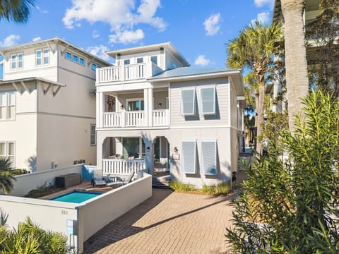 Stunning coastal cottage with private pool surrounded by swaying palms and tropical landscaping in this peaceful beachside neighborhood.