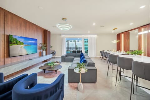 Modern open living and dining area with a large sectional sofa and bar seating.