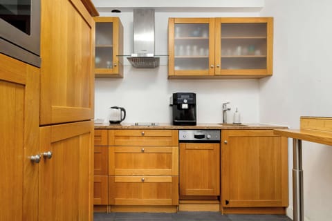 Wood-finished kitchenette with storage cabinets, countertop, and practical layout.