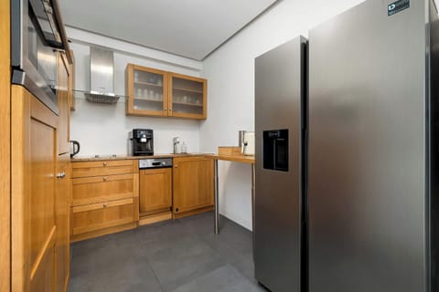Wood-finished kitchenette with storage cabinets, countertop, and practical layout.