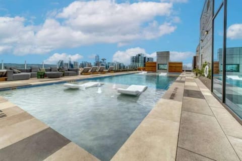 Relax by the rooftop pool with comfortable seating and open views