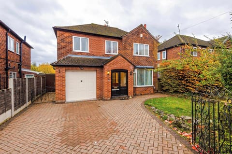 Exterior: Charming brick façade nestled in autumn colors, perfect for your getaway in Wythenshawe!