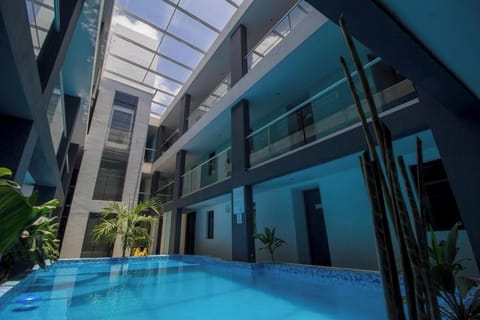 Dive into a sleek indoor-outdoor pool under a skylit atrium.