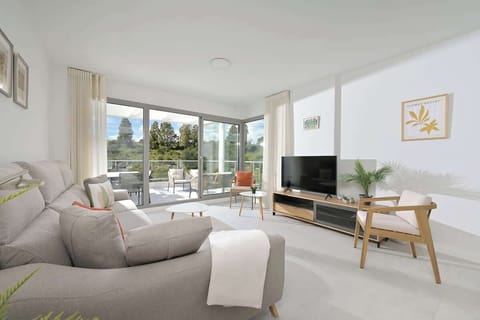 Spacious open living area with comfy sofa, kitchen, and dining for guests to enjoy.