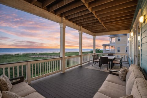 Spacious covered beachfront deck with outdoor dining and Gulf views at a luxury Galveston beach house rental.