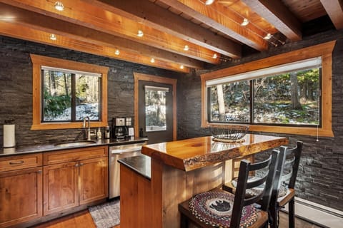 Your modern mountain kitchen blends rustic warmth with sleek functionality, featuring exposed beams and forest views.