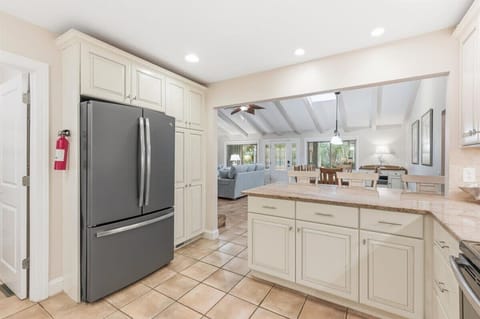 Modern kitchen with granite counters, stainless appliances, and a breakfast bar for three.