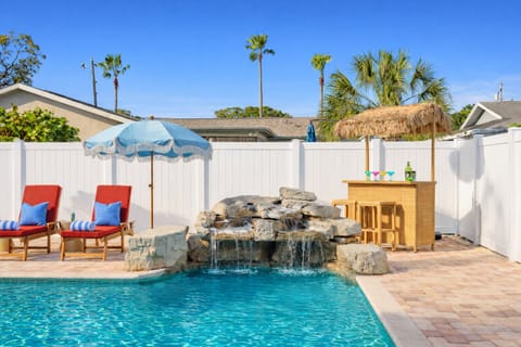 Rock waterfall and tiki bar create a true backyard resort feel