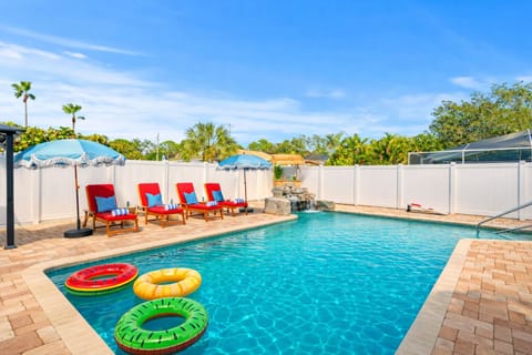 Spacious pool with sun loungers and floaties. 