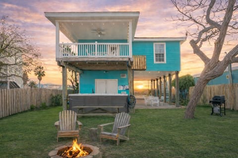Rear exterior of the house showing the deck, hot tub, and yard.
