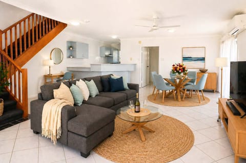 Sunlit living and dining space blending comfort with coastal elegance.