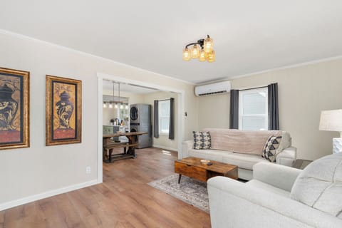 Sink into the cozy couch, enjoy the glow of ceiling lights, and soak in the artful wall vibes! 🛋️