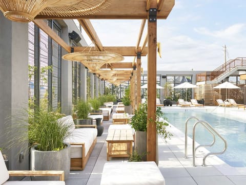 Long pool view with loungers, umbrellas, and wood structures