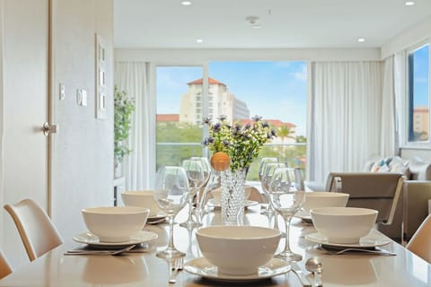 Gather around your elegant dining table where fresh flowers and city views create the perfect backdrop for memorable meals together.