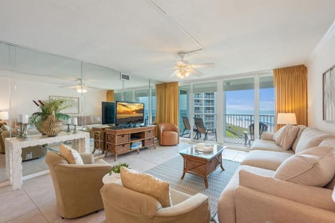 Relax in your elegant beachfront living room with floor-to-ceiling windows framing stunning ocean views and your private balcony.
