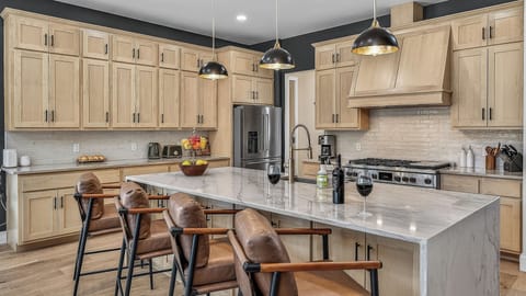 Kitchen, Main Level - Large island with bar seating and modern appliances.