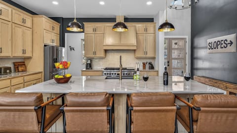 Kitchen, Main Level - Large island with bar seating and modern appliances.