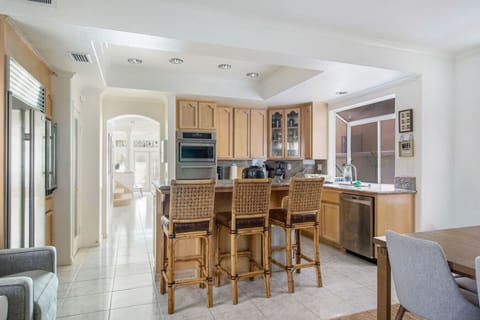 Fully stocked kitchen with stainless steel appliances and island seating for three