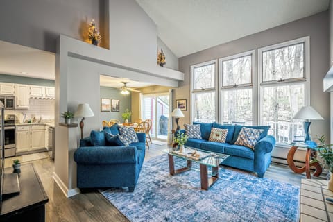 A bright, open living space with vaulted ceilings, forest views, and cozy seating—perfect for gathering after a day in the Poconos.