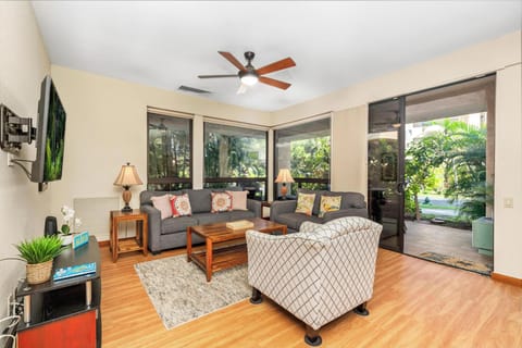 Unwind in your spacious living room with plush seating, tropical garden views, and warm wood floors that invite barefoot mornings.