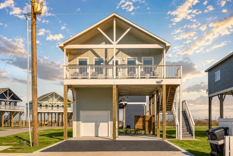 Elevated beach house exterior with covered parking, spacious balcony, and coastal design in Bolivar Peninsula near Crystal Beach.