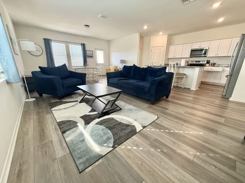 Unwind in the expansive living room, featuring a seamless open floor plan that flows into the kitchen/dining area.