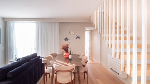 Stylish dining and lounge area with designer lighting, a warm wooden staircase, and a welcoming open-plan layout.
#DesignLiving #PortoDuplex #ModernHospitality #ElegantStay