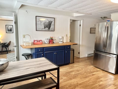 Surrounding the fireplace is an open-concept layout where the living room, kitchen, and dining area flow together seamlessly, allowing for easy connection and conversation.