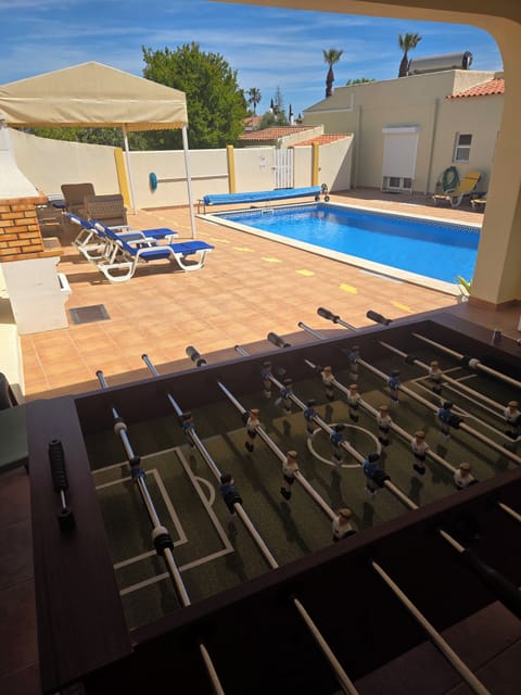 Shaded outdoor games room with TV, Fooseball, and Seating area