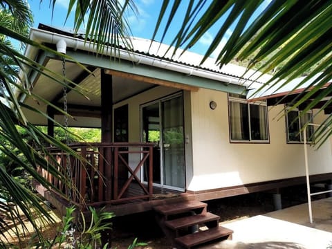 Exterior view of the tropical home with covered entrance and greenery