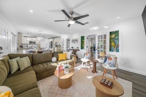 An open-concept living area filled with natural light, featuring a large sectional, accent chairs, and a sleek entertainment setup for laid-back evenings.