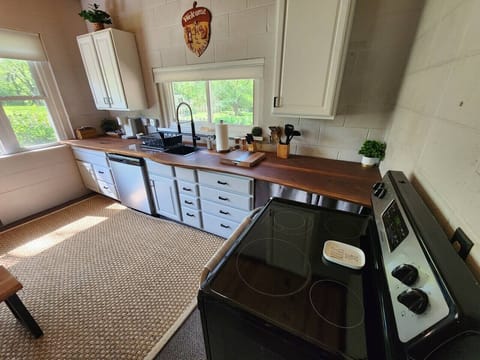 Enjoy preparing meals in a thoughtfully designed kitchen with a cozy wooden ceiling and a warm natural feel