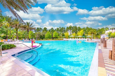 Family-friendly outdoor pool surrounded by tropical landscaping and lounge chairs.