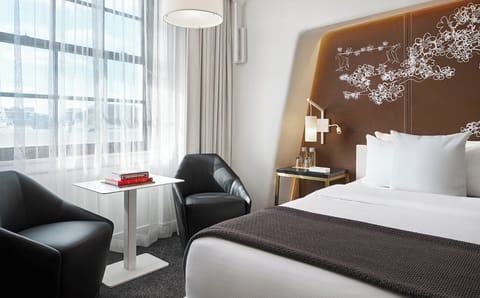 Sink into crisp linens beside sunlit windows and lounge chairs.