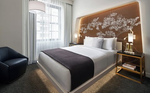 Sink into crisp linens beneath an artful, glowing headboard.