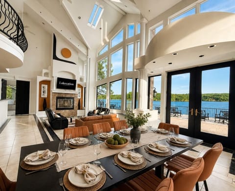 Elegant lakefront luxury home with soaring ceilings, floor-to-ceiling windows, designer living spaces, and expansive dining—perfect for group getaways
