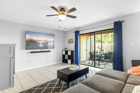 Bright & airy living room featuring sliding glass doors that lead to outdoor screened in patio
