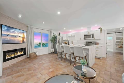 Modern elegance meets cozy comfort—an inviting open-concept space with stunning sunset views and a warm fireplace glow.