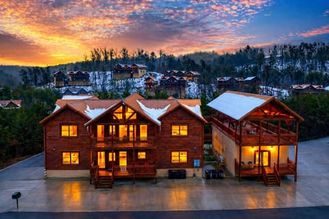 Golden-hour mountain retreat glowing at dusk, with expansive decks, cozy cabin charm, and sweeping Smoky Mountain views in every direction.