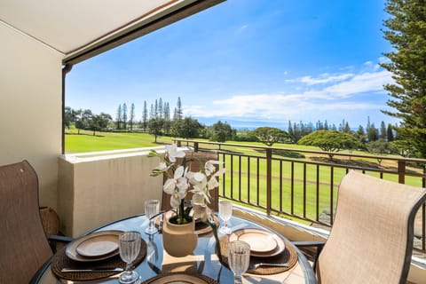 Start your day with breakfast on this serene balcony overlooking lush greenery and distant ocean views.