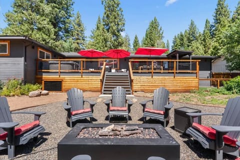 Beautiful outdoor living space that includes a gas fire pit, large deck, hot tub, lounge furniture, dining table, gas grill, side yard with ping pong table (coming in summer 2026) & hammock (note only available during summer months).