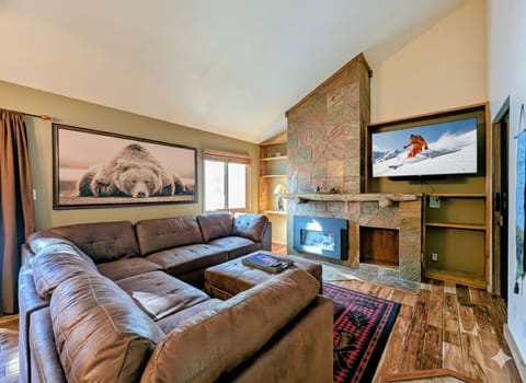 Sink into this plush sectional by your cozy stone fireplace, where mountain adventures play on the big screen.