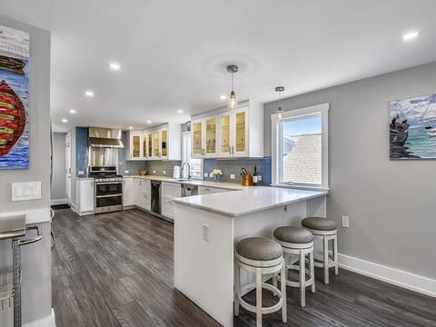 The modern kitchen features a quartz peninsula, bar seating, and state-of-the-art appliances, making cooking a pleasure.