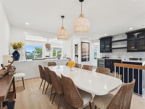With a seamless transition to the modern kitchen, this elegant dining space is characterized by warm tones and chic pendant lighting, creating an inviting atmosphere for entertaining.