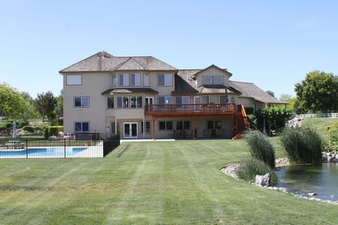 back yard view with pool, waterfall, hot tub, deck, grass volleyball court