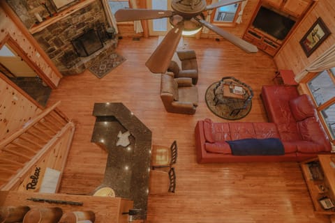 Pool table and entertainment room — TV, sofa seating, and cue rack