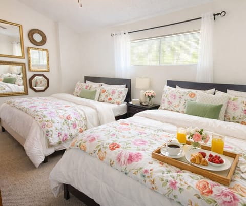 Spacious guest bedroom with two comfortable queen-size beds, bright natural light, and cozy décor—perfect for families and group-friendly vacation stays.