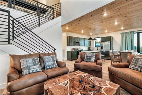 Relax in your spacious living room with rich leather seating and warm wood ceiling. The open-plan design flows into a modern kitchen perfect for your getaway.