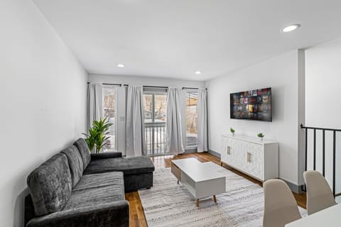 Comfortable living area with sectional sofa and large windows that bring in natural light. Perfect for unwinding after work or hosting a quiet movie night. The open layout keeps the space airy while still feeling cozy for extended stays.