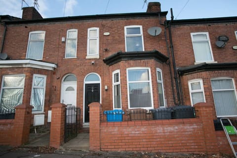 The front exterior shows a red-brick terraced property with a small frontage.